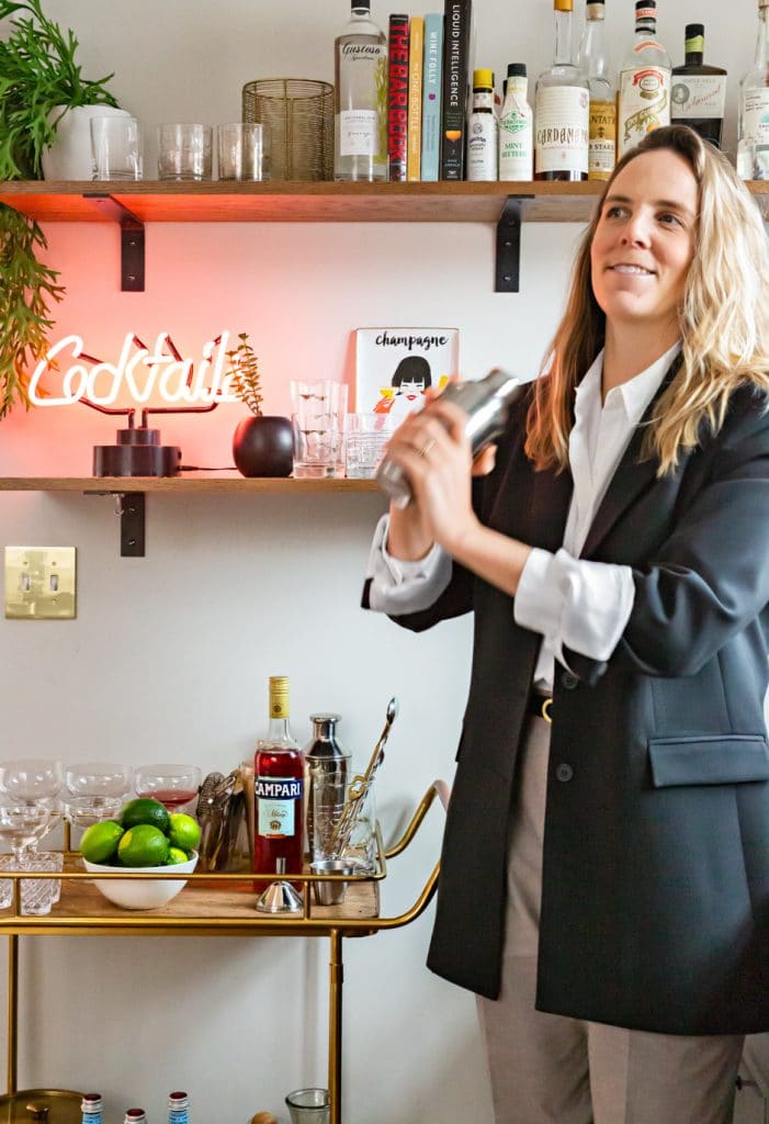pippa standing in bar nook making cocktail