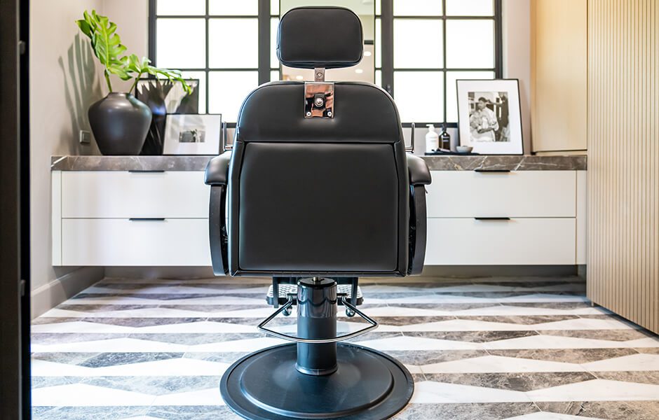 Barber chair in a modern grooming station with geometric flooring and decorative accents