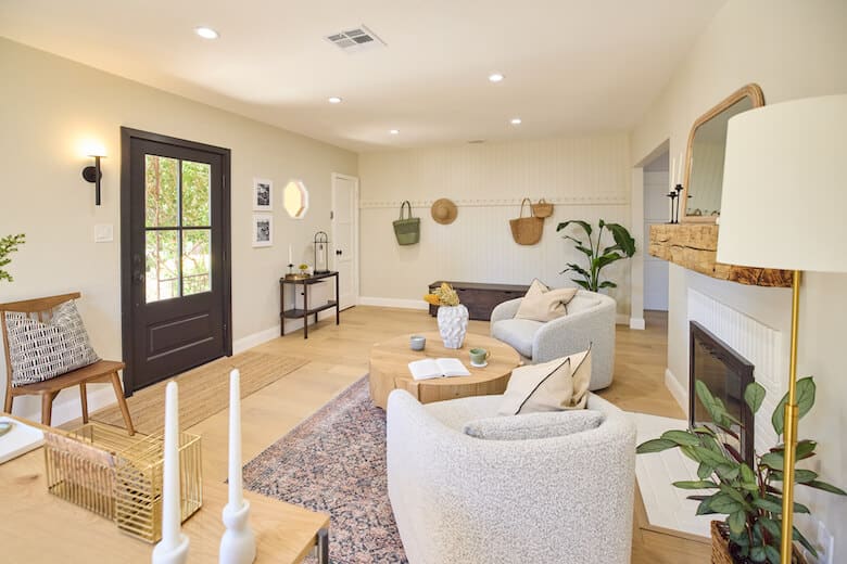 Bright living room with armchairs, wood flooring, and a fireplace
