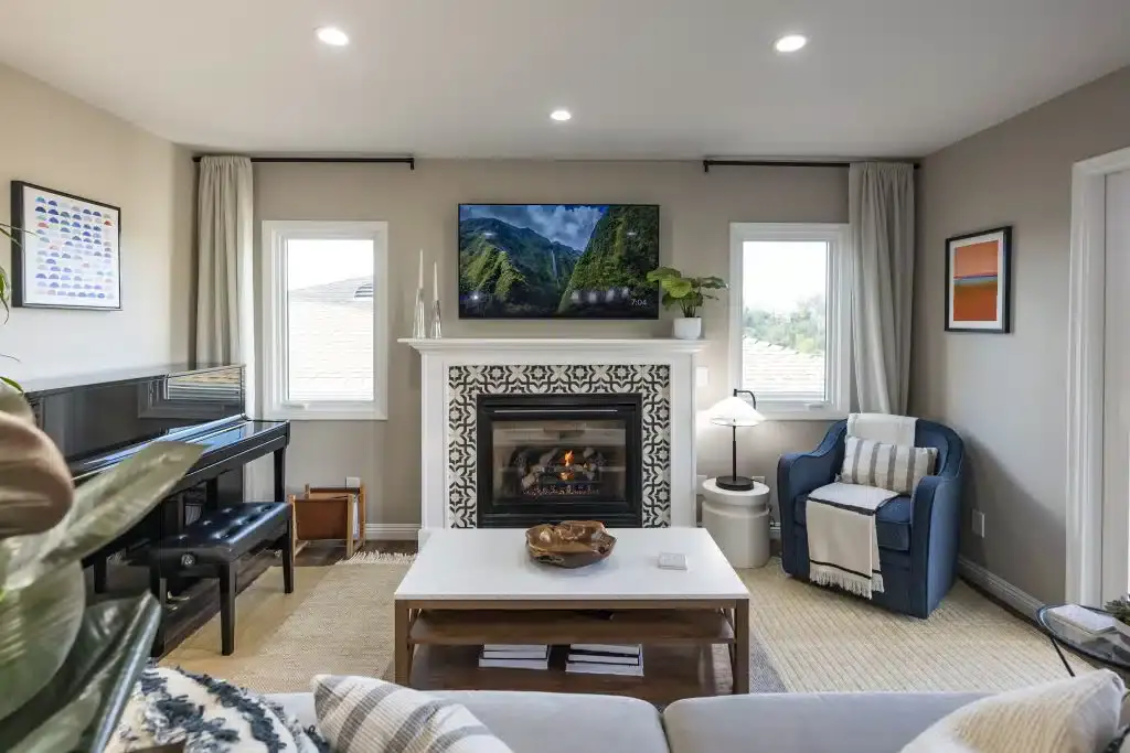 Living room with grand piano, fireplace, TV, and striped armchair
