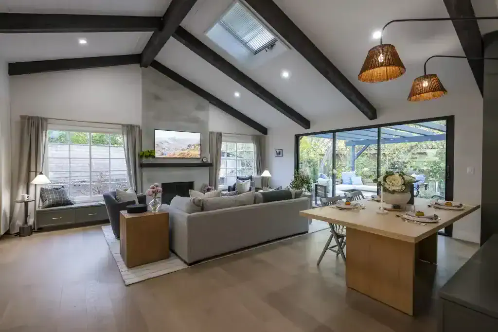 Open living and dining area with vaulted ceiling and sliding doors