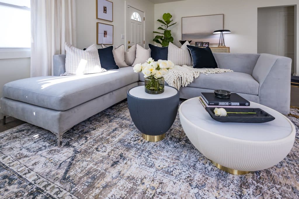 Modern living room with gray sectional, round tables, and decorative accents