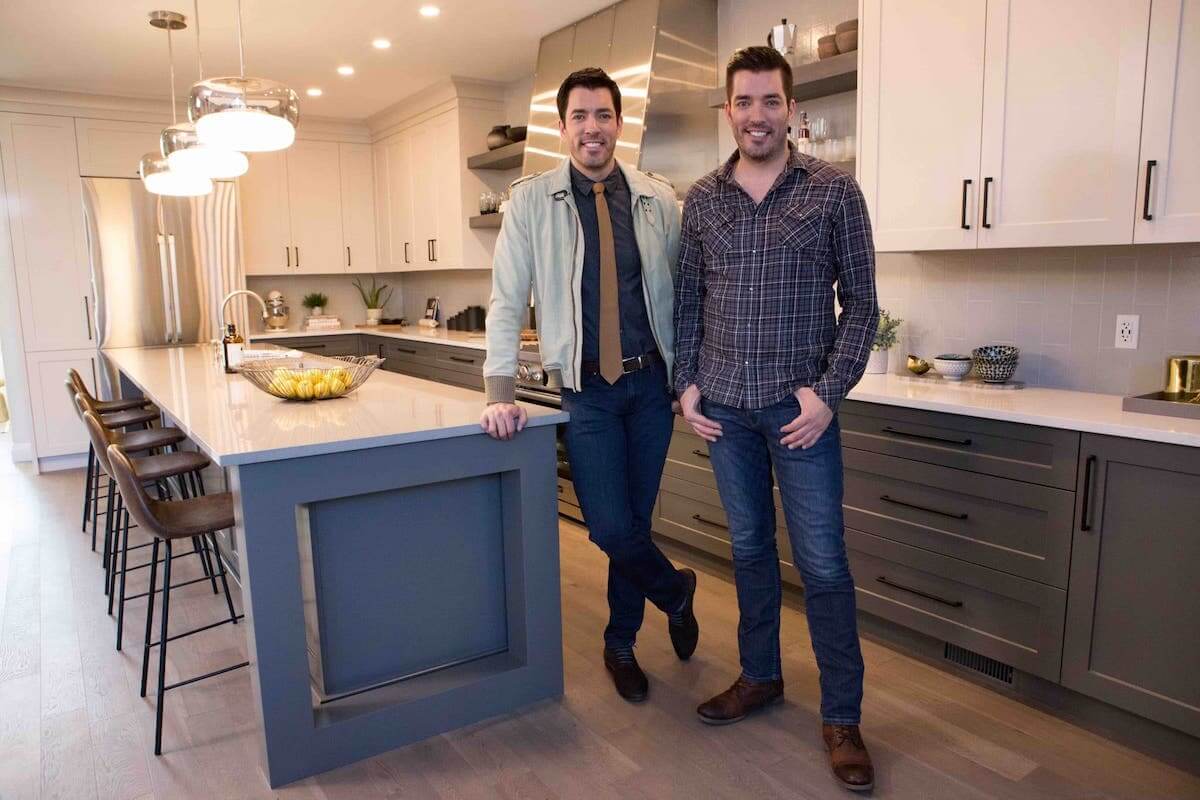 Drew and Jonathan in a modern kitchen with gray cabinets and a large island