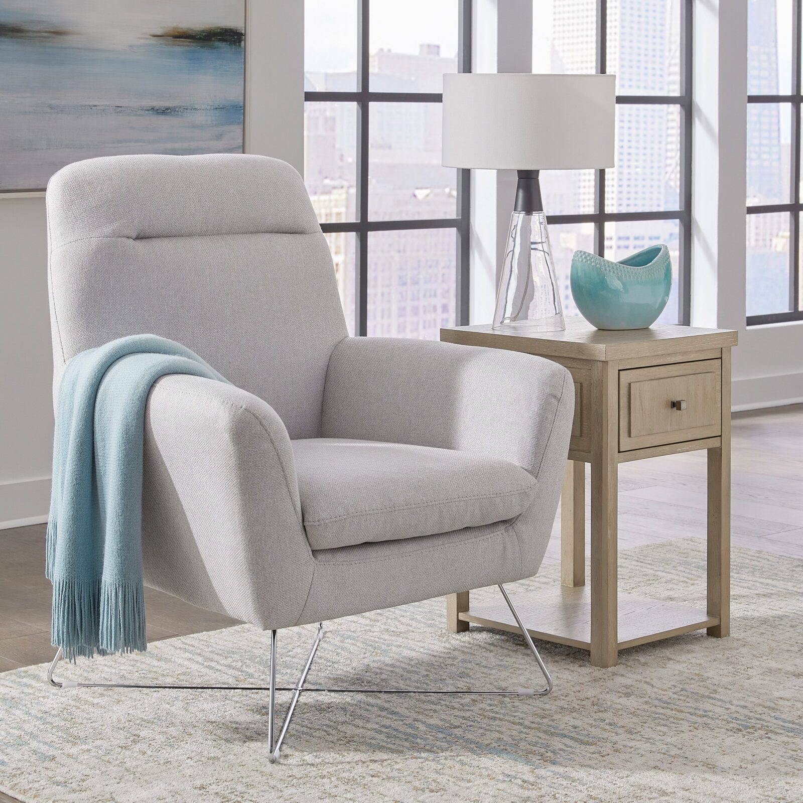 Modern reading corner with a light gray armchair, wooden side table, glass lamp, and city view