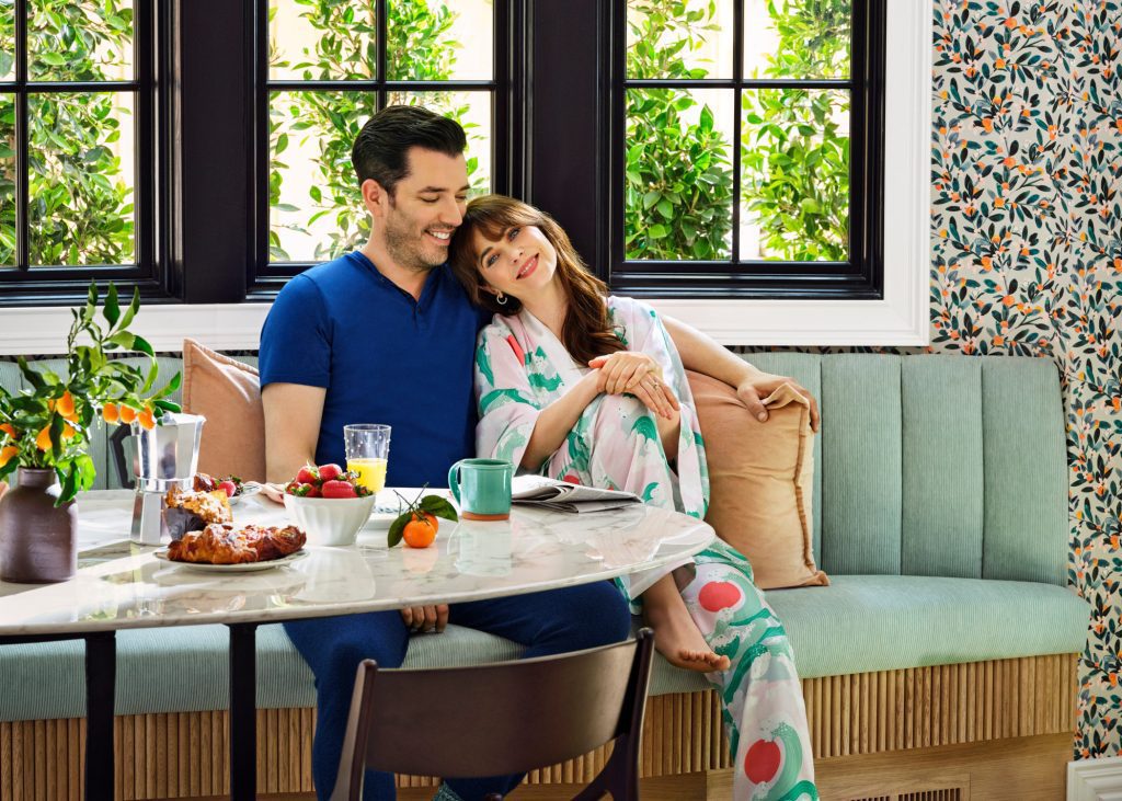 Jonathan and Zooey enjoying breakfast together on a light green bench in a bright, colorful kitchen nook