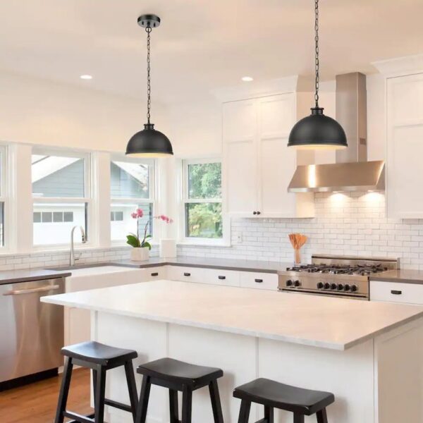 Bright kitchen with white cabinets, black stools, and pendant lights