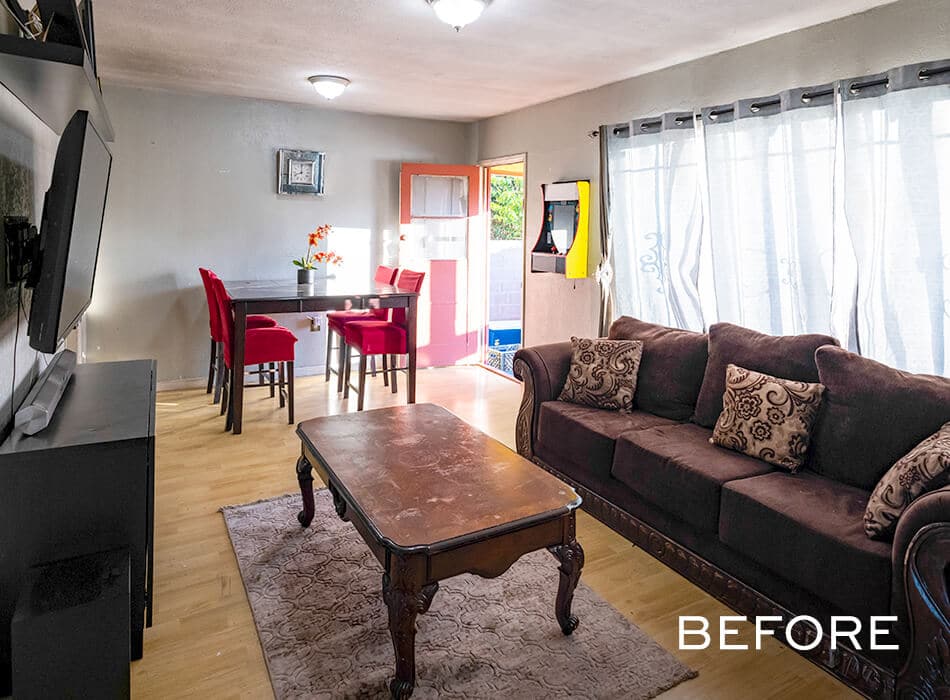Before living room with brown sofa, red dining chairs, and wood furniture