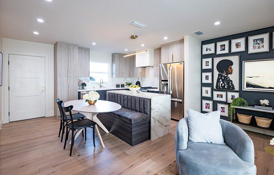 Renovated kitchen featuring a breakfast bar, a round dining table, and a gallery wall