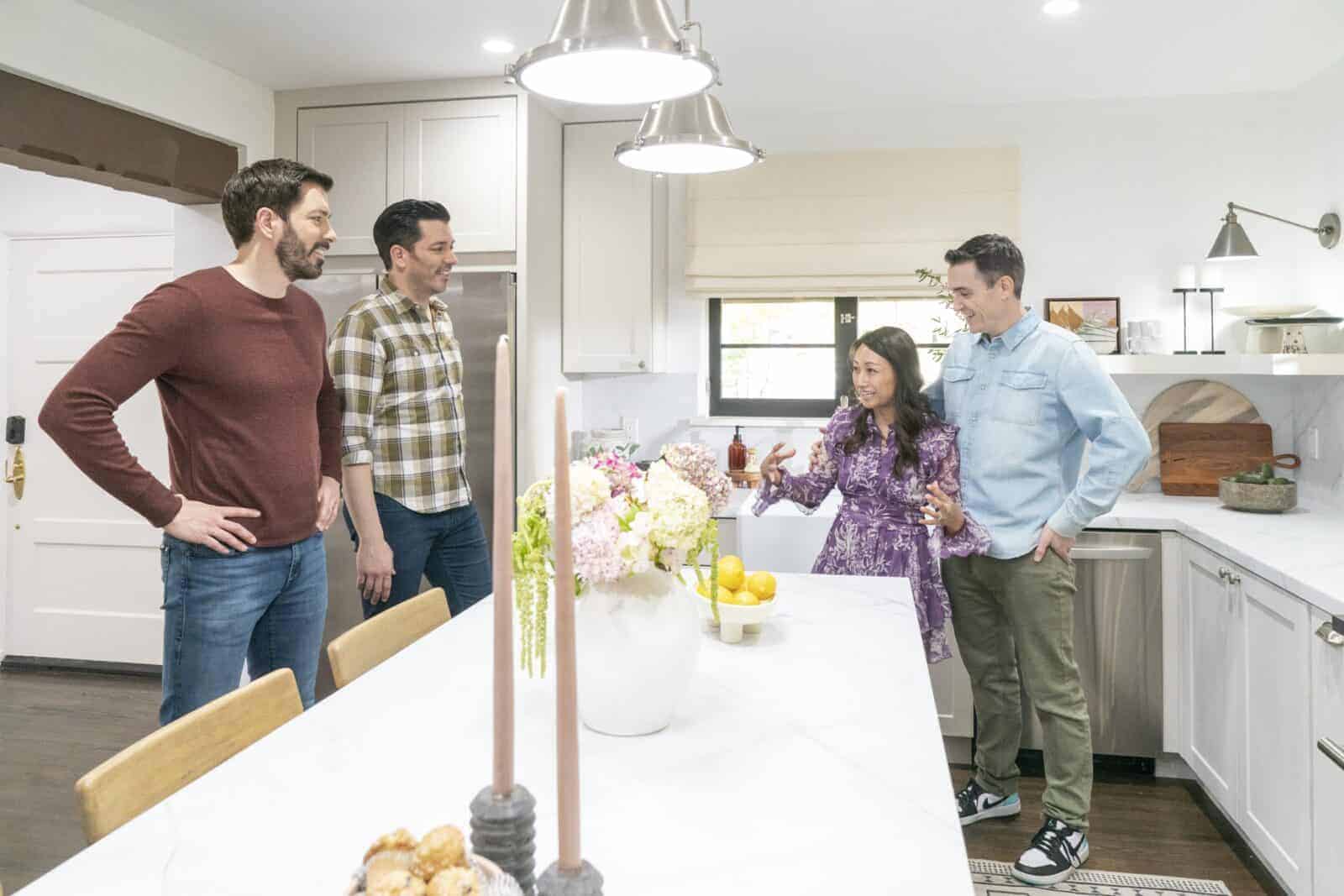 Drew and Jonathan Scott with a couple in a bright modern kitchen