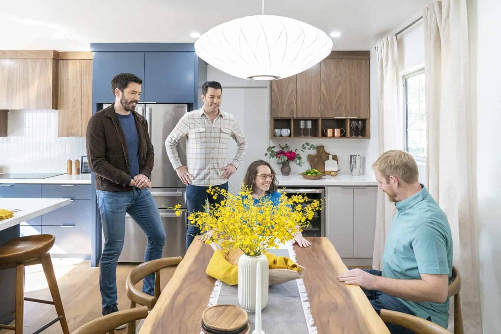Drew and Jonathan Scott with a couple in a modern kitchen and dining area