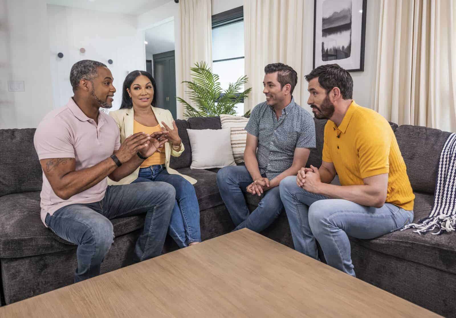 Drew and Jonathan Scott sitting with a couple in a cozy living room, having a conversation