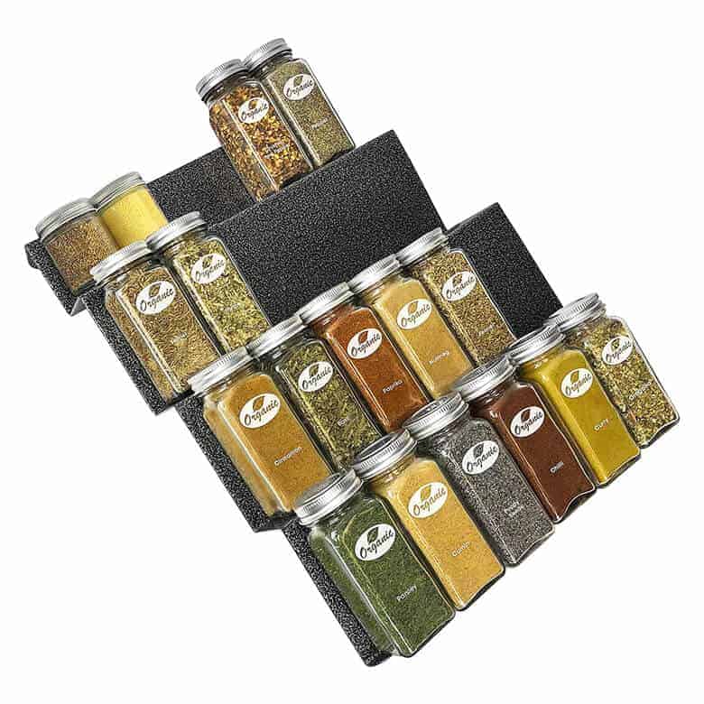 Tiered spice rack organizer with labeled glass jars filled with assorted organic spices