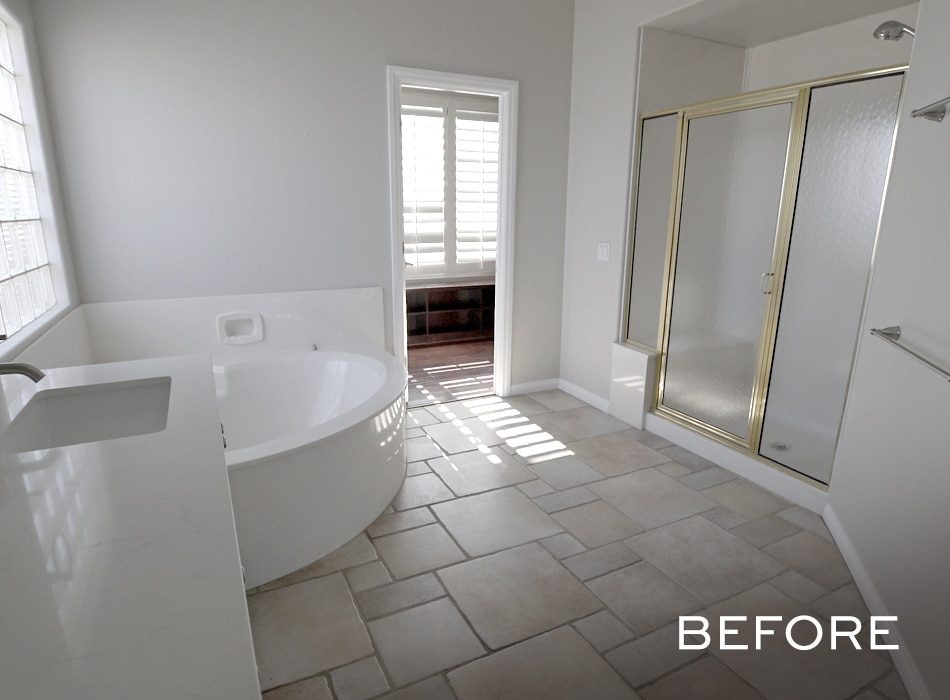 Spacious bathroom with beige tile floors, a corner tub, and a glass shower with gold trim