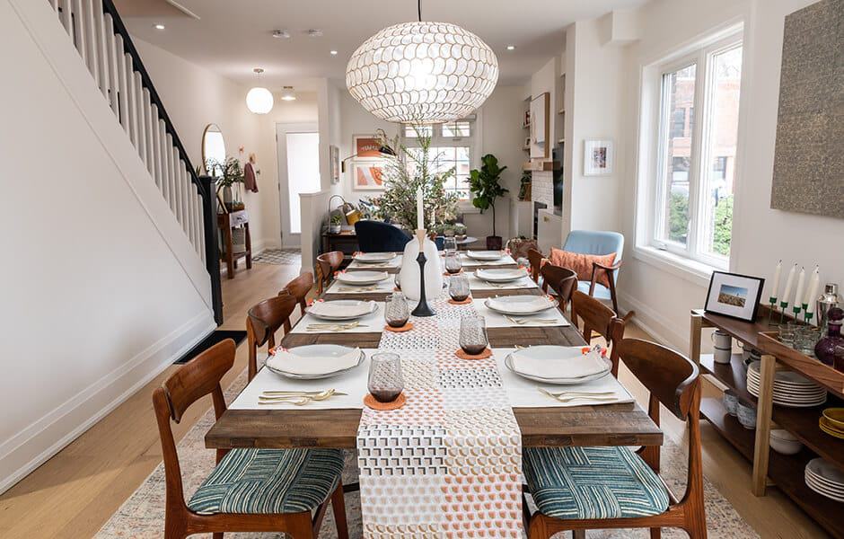 Modern dining room with long table, patterned runner, and pendant light