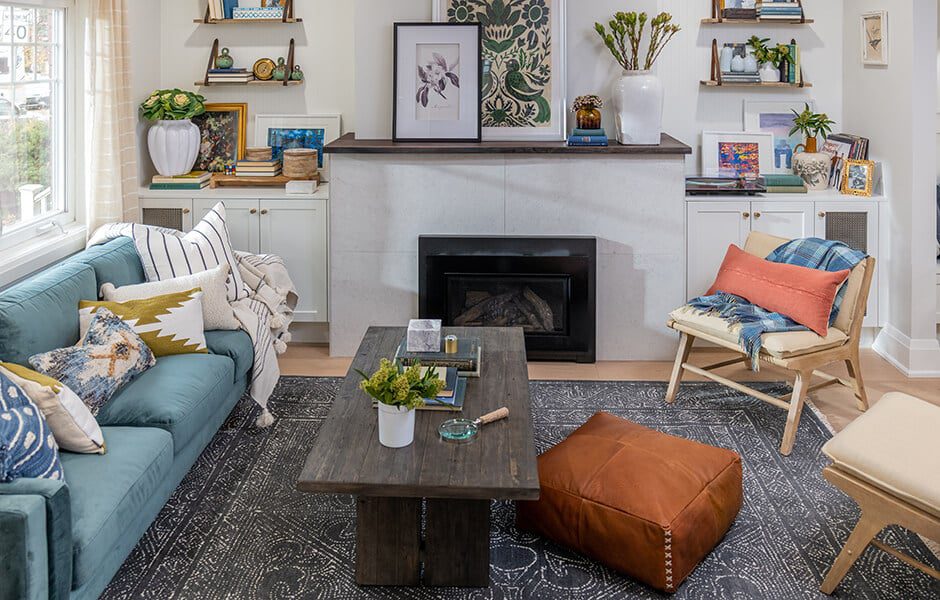 Cozy living room with teal sofa, wood coffee table, fireplace, and layered decorative accents