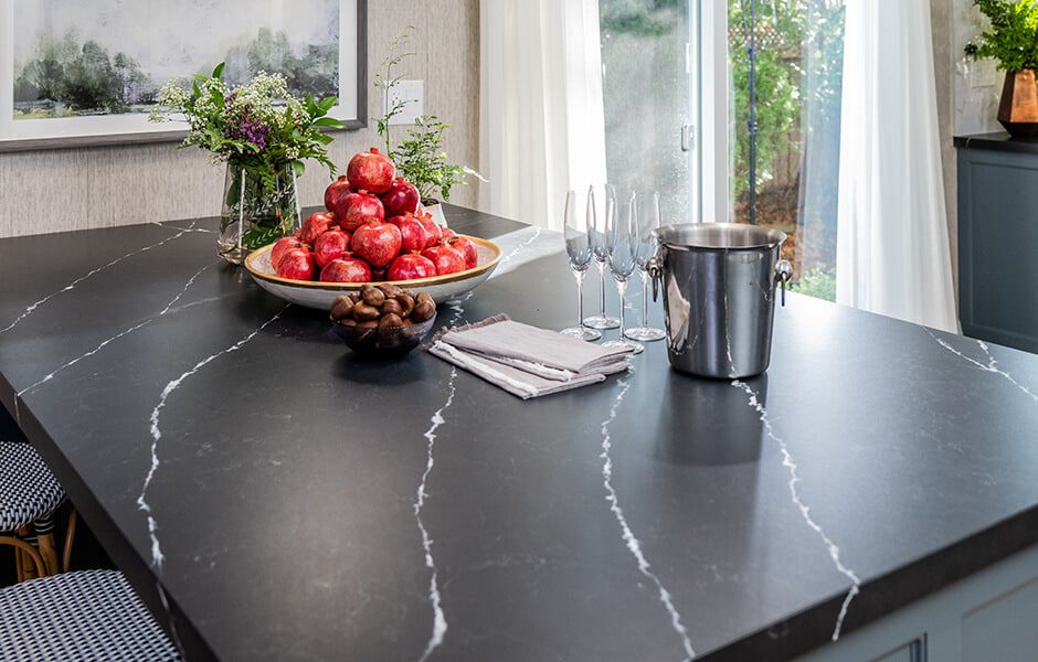 Black marble island with pomegranates, flowers, glasses, and ice bucket