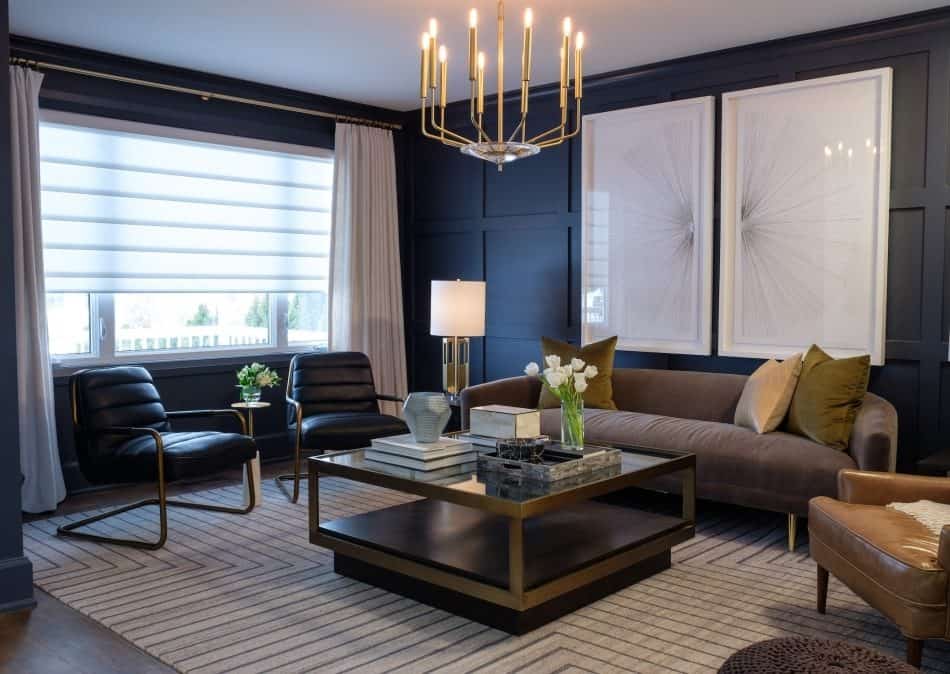 Sophisticated living room with dark accent walls, modern furniture, striped rug, and a gold chandelier
