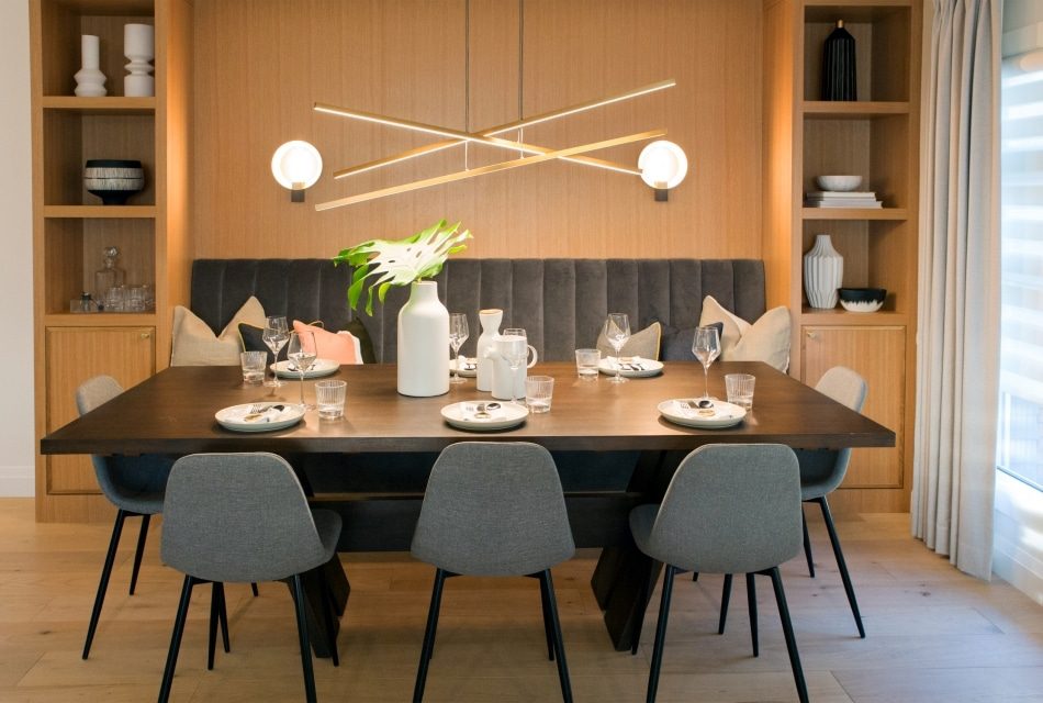 Dining room with gray upholstered chairs, a dark wooden table, and built-in wooden shelving