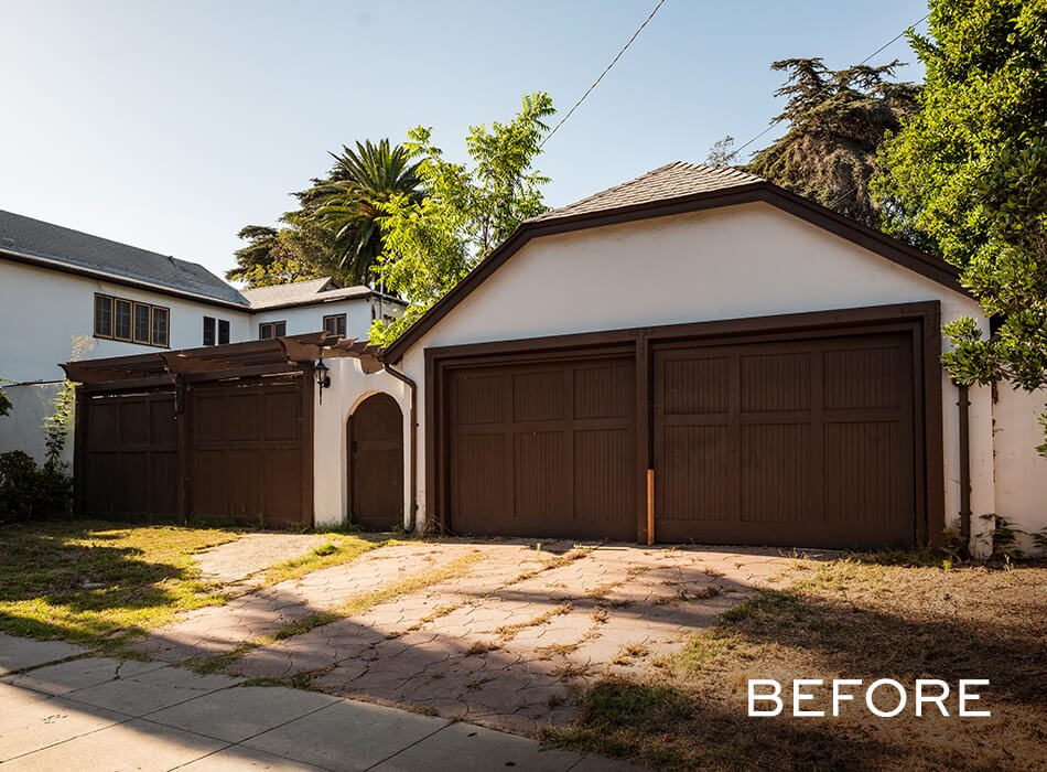 Aged double garage with dark brown doors, cracked driveway, and minimal landscaping