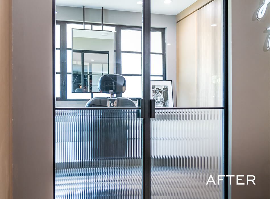 Modern office space with glass doors, desk, and chair