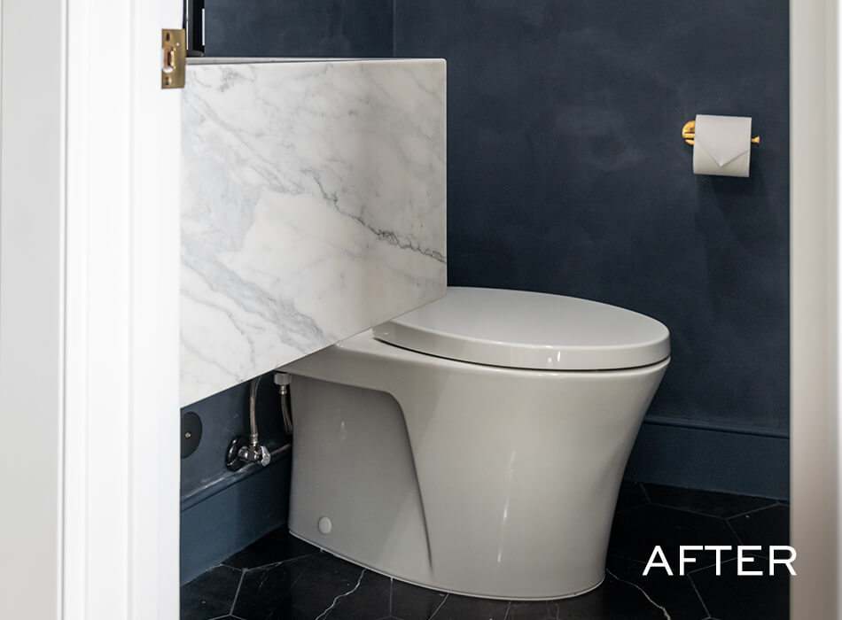 Bathroom with modern toilet, marble accent, and dark walls