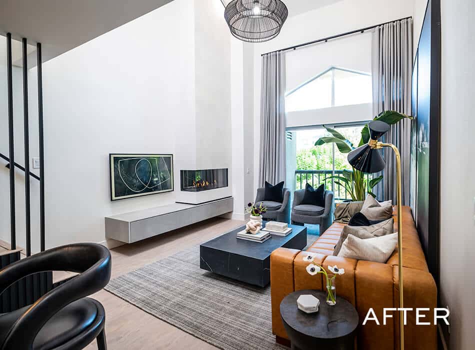 Modern living room with leather sofa, fireplace, and large windows