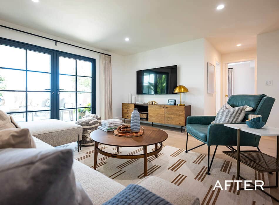 Cozy living room with large windows, sectional sofa, armchair, and wall-mounted TV