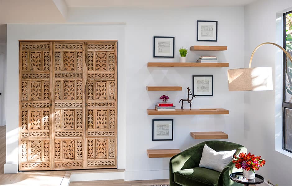 Living room corner with carved wooden sliding doors and floating shelves