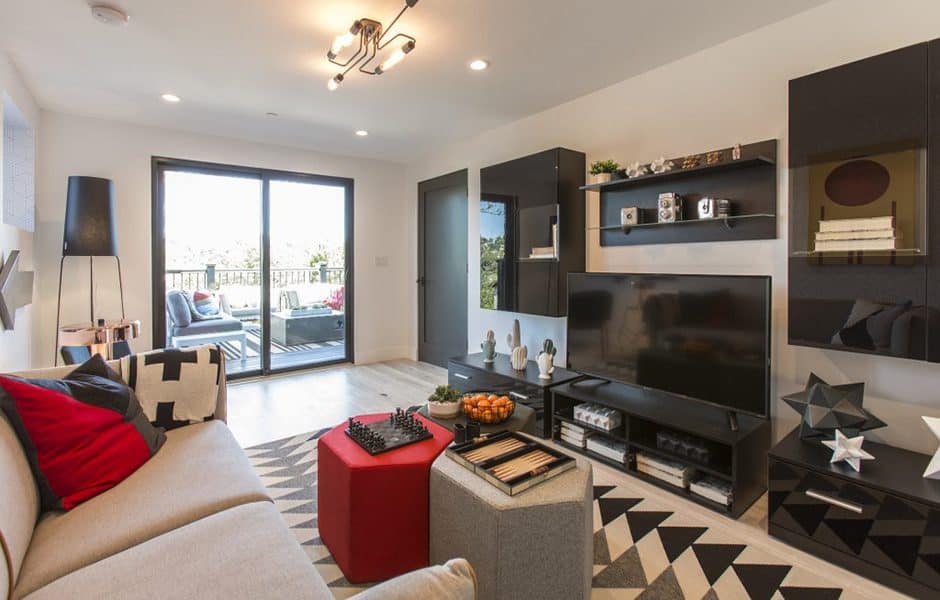 Modern living room with geometric decor, black shelving, and a sliding door to the patio