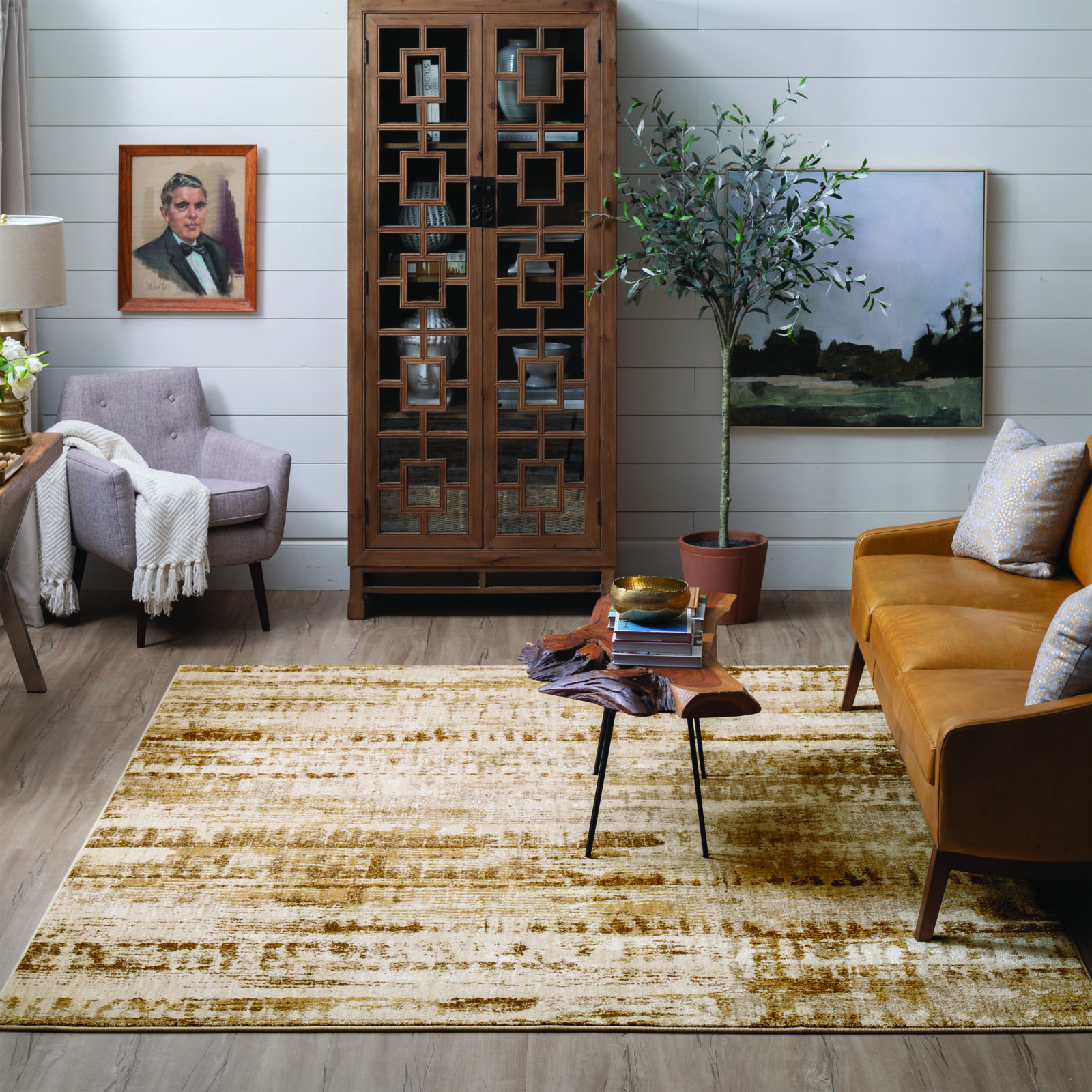 Cozy living room with a mustard sofa, wooden cabinet, abstract artwork, and a textured area rug