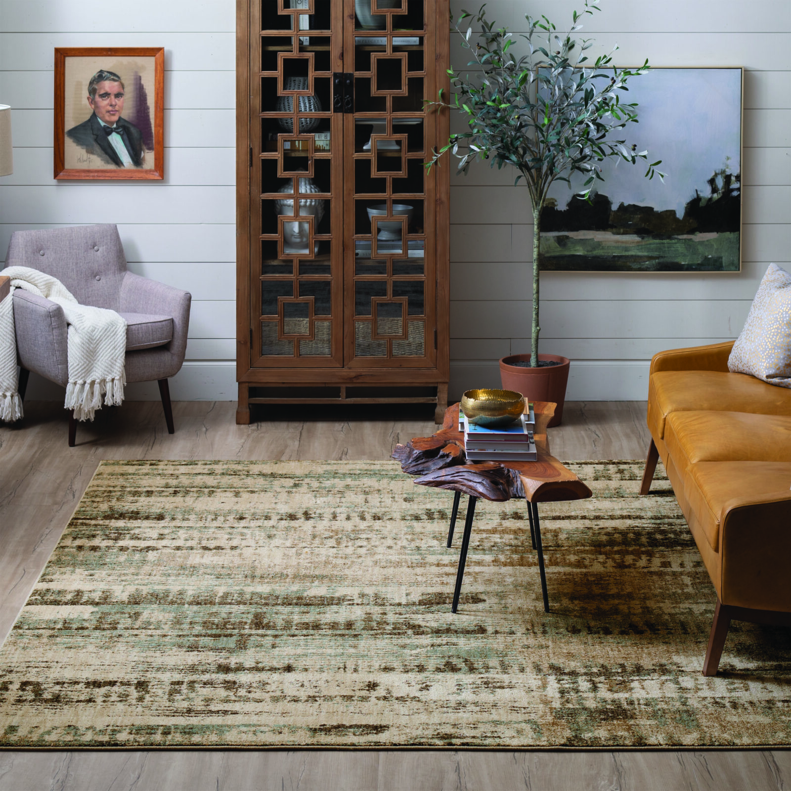 Living room with modern furniture, artwork, wooden cabinet, and a potted tree