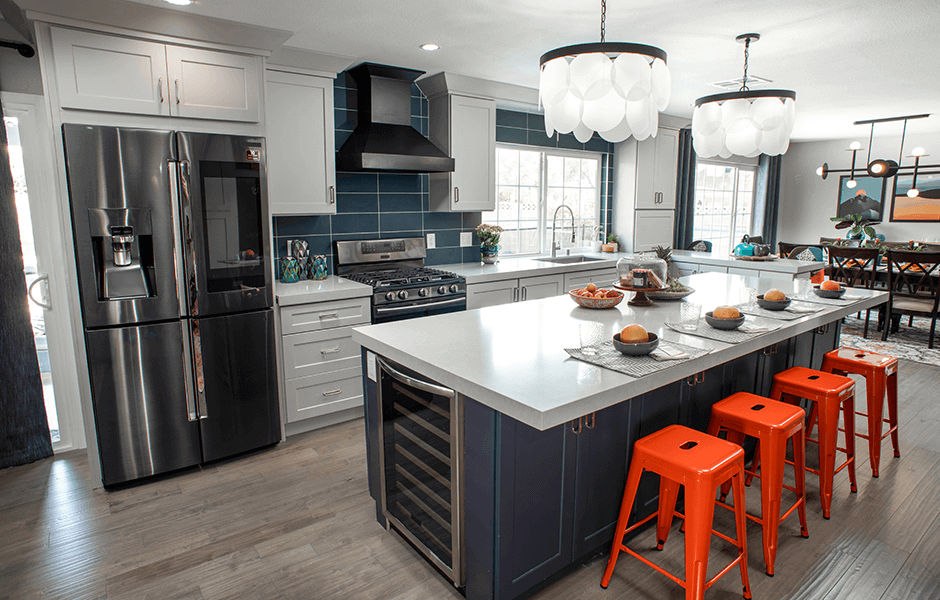 Modern kitchen with stainless steel appliances, a large island, and bright orange bar stools