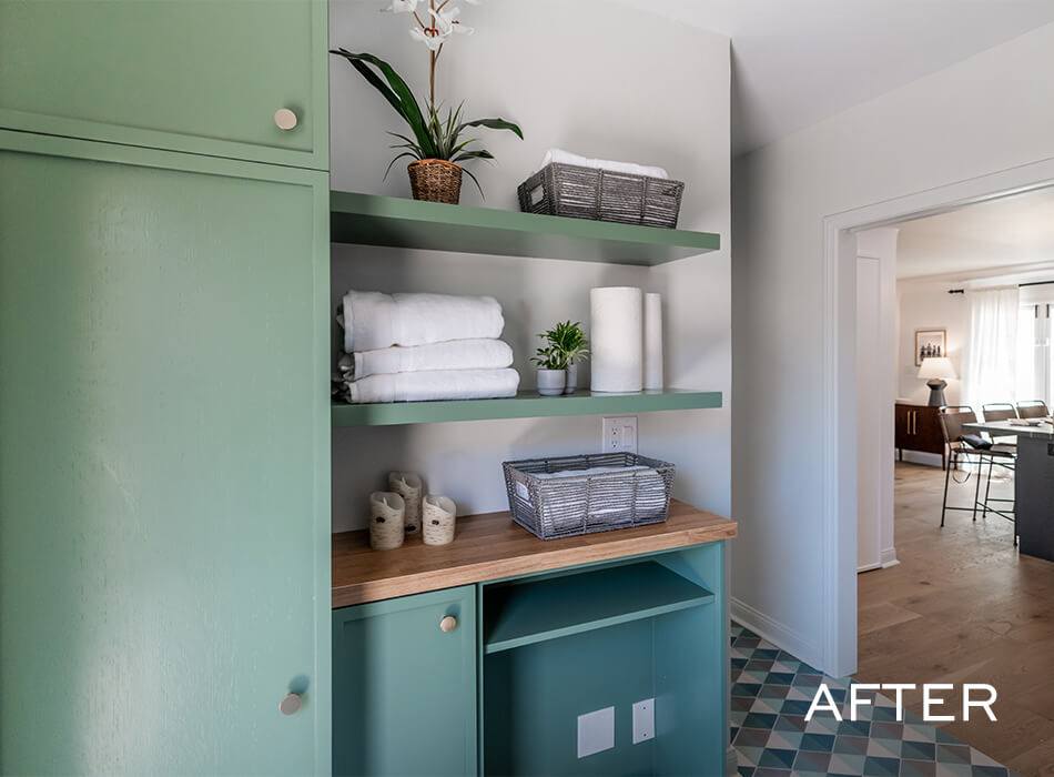 Organized storage nook with green shelves holding towels, baskets, and plants