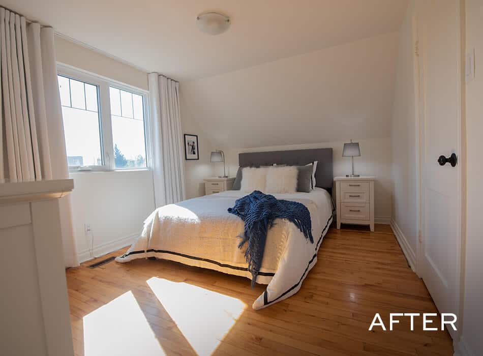Bright bedroom with bed, white bedding, blue throw, and natural light from windows