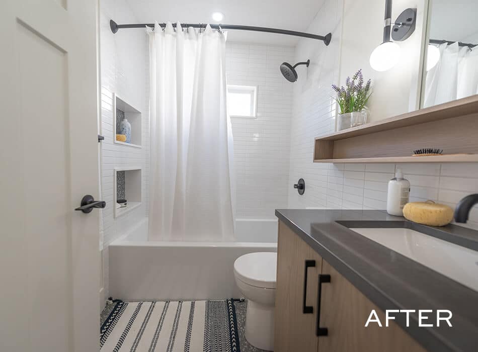 Modern bathroom with tub, white shower curtain, dark vanity, and built-in shelves