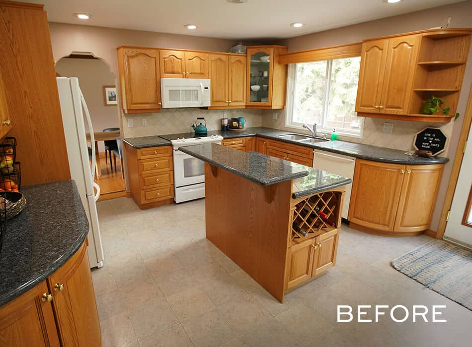Kitchen with wooden cabinets, dark countertops, center island with wine storage, and white appliances