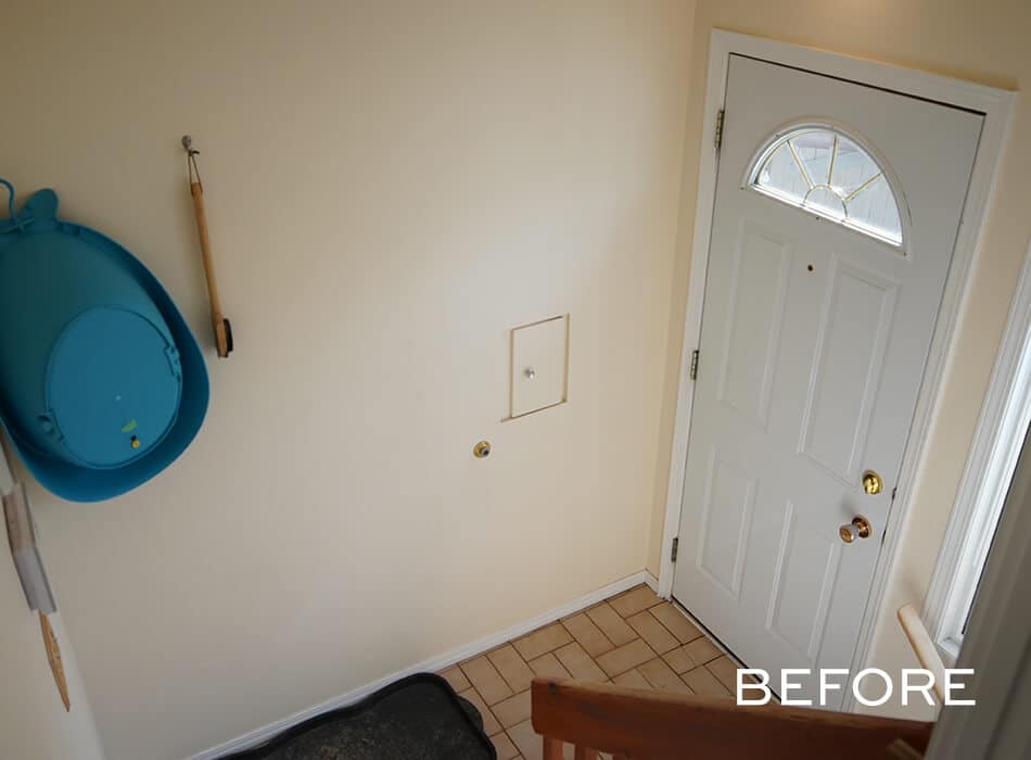 Simple entryway with a white front door, tiled floor, and a blue sled hanging on the wall