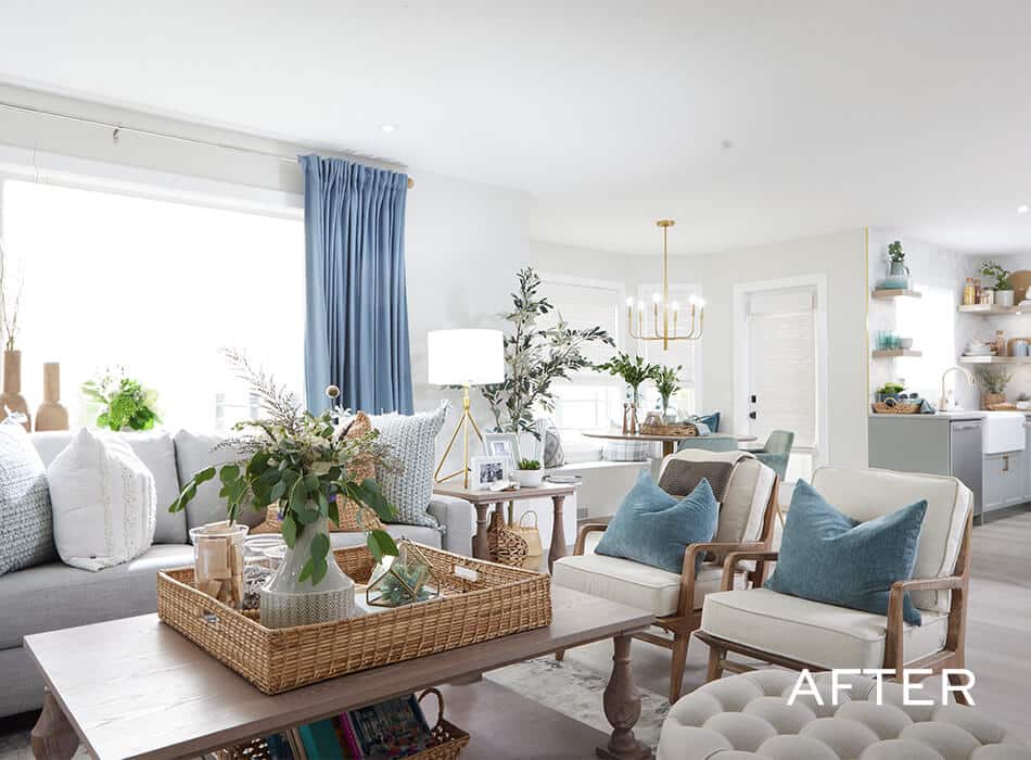 Bright living room with gray sofa, white armchairs, blue pillows, and coffee table
