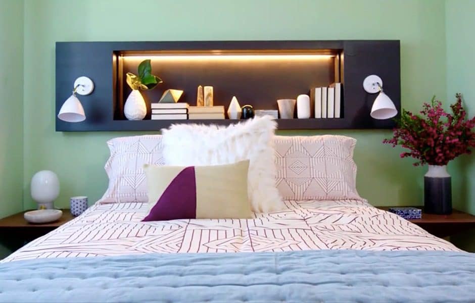 Modern bed with geometric bedding, built-in shelf headboard, and decorative accents