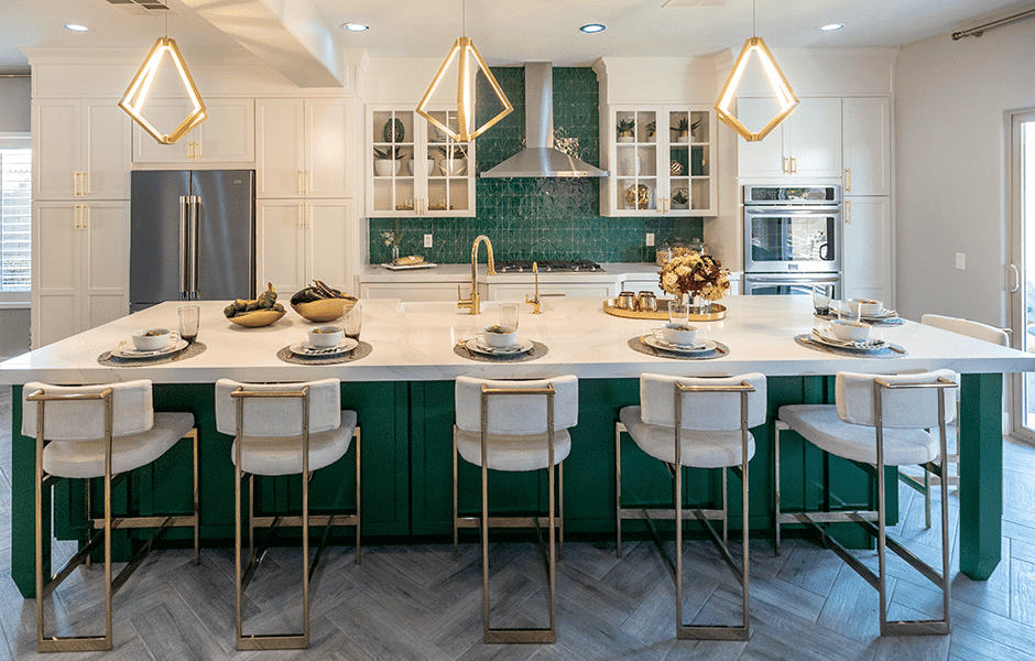 Elegant kitchen with green island, gold accents, geometric pendant lights, and white cabinetry