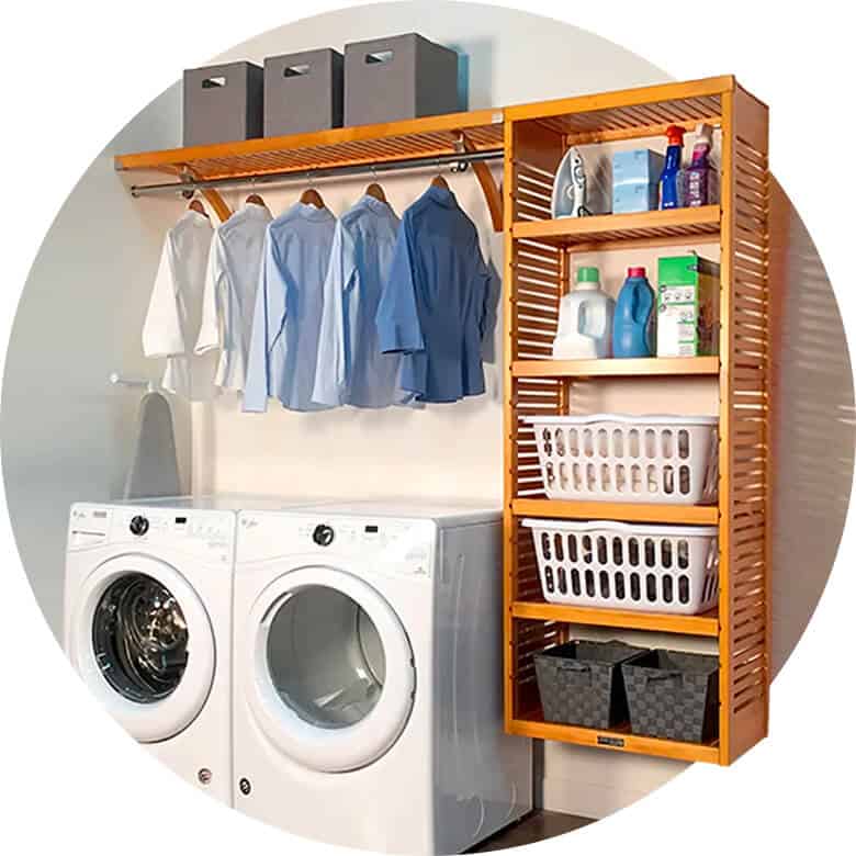 Laundry room with washer, dryer, wooden shelves, baskets, detergents, and hanging shirts