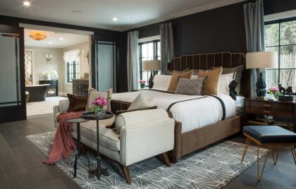 Elegant bedroom with dark walls, a large bed, and a sitting area