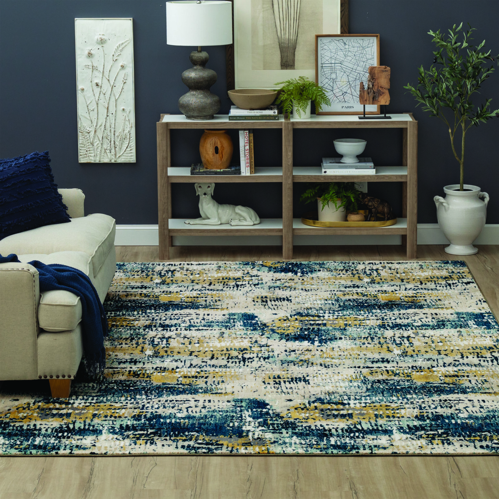 Multicolor abstract rug in a cozy, dark-toned living room with neutral furniture and decorative shelving