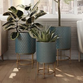 Blue planters with gold stands and indoor greenery