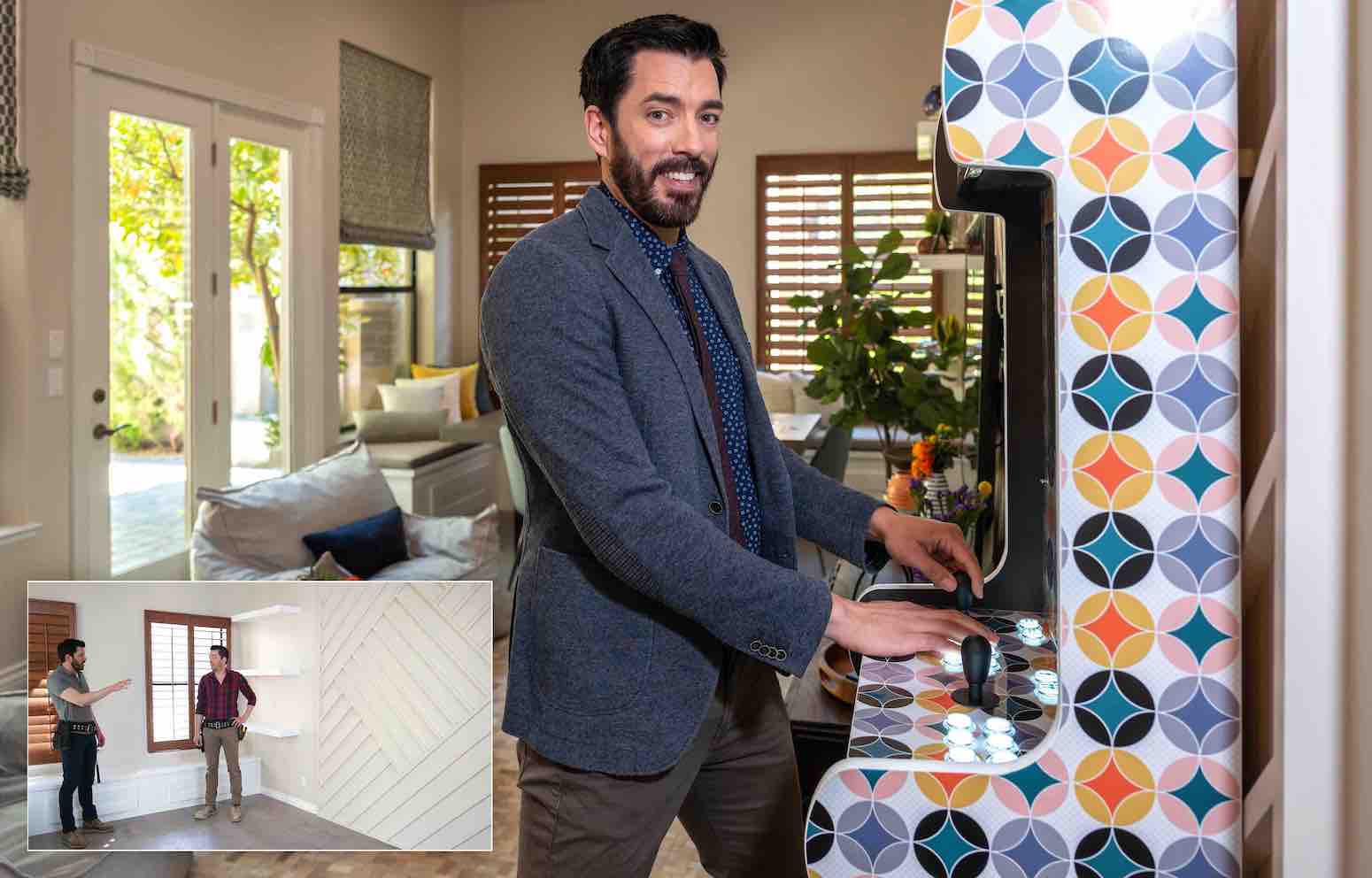 Drew Scott in a modern room playing a colorful arcade game, with cozy seating, natural light, and a plant-filled background