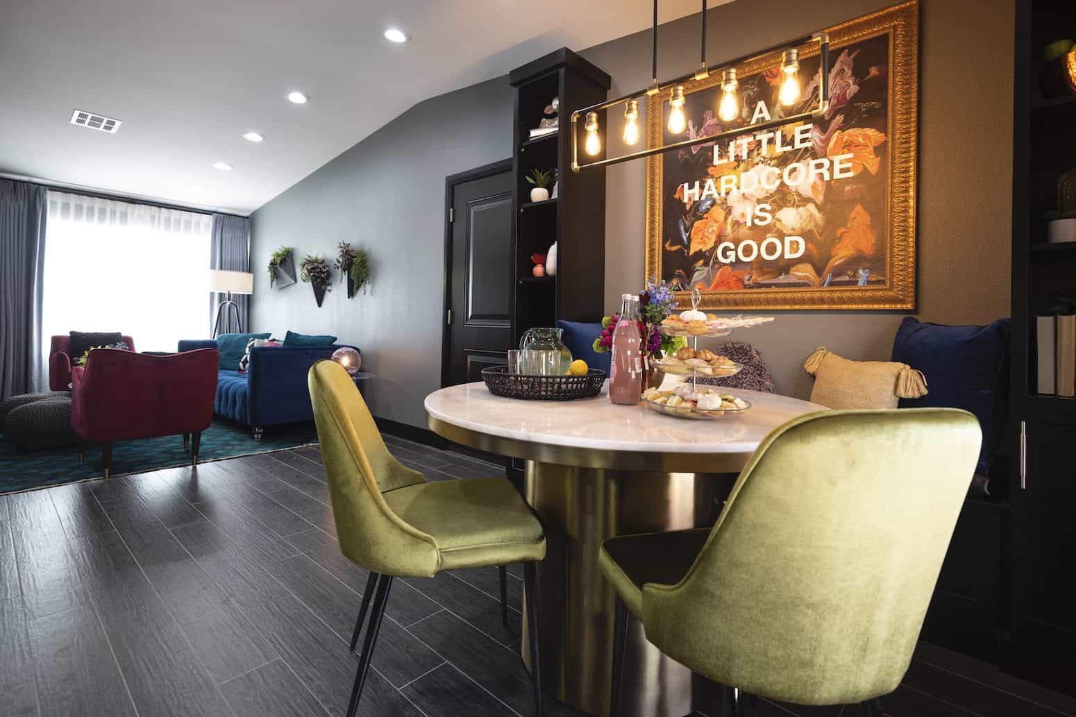 Modern dining area with a marble table, velvet chairs, and framed artwork