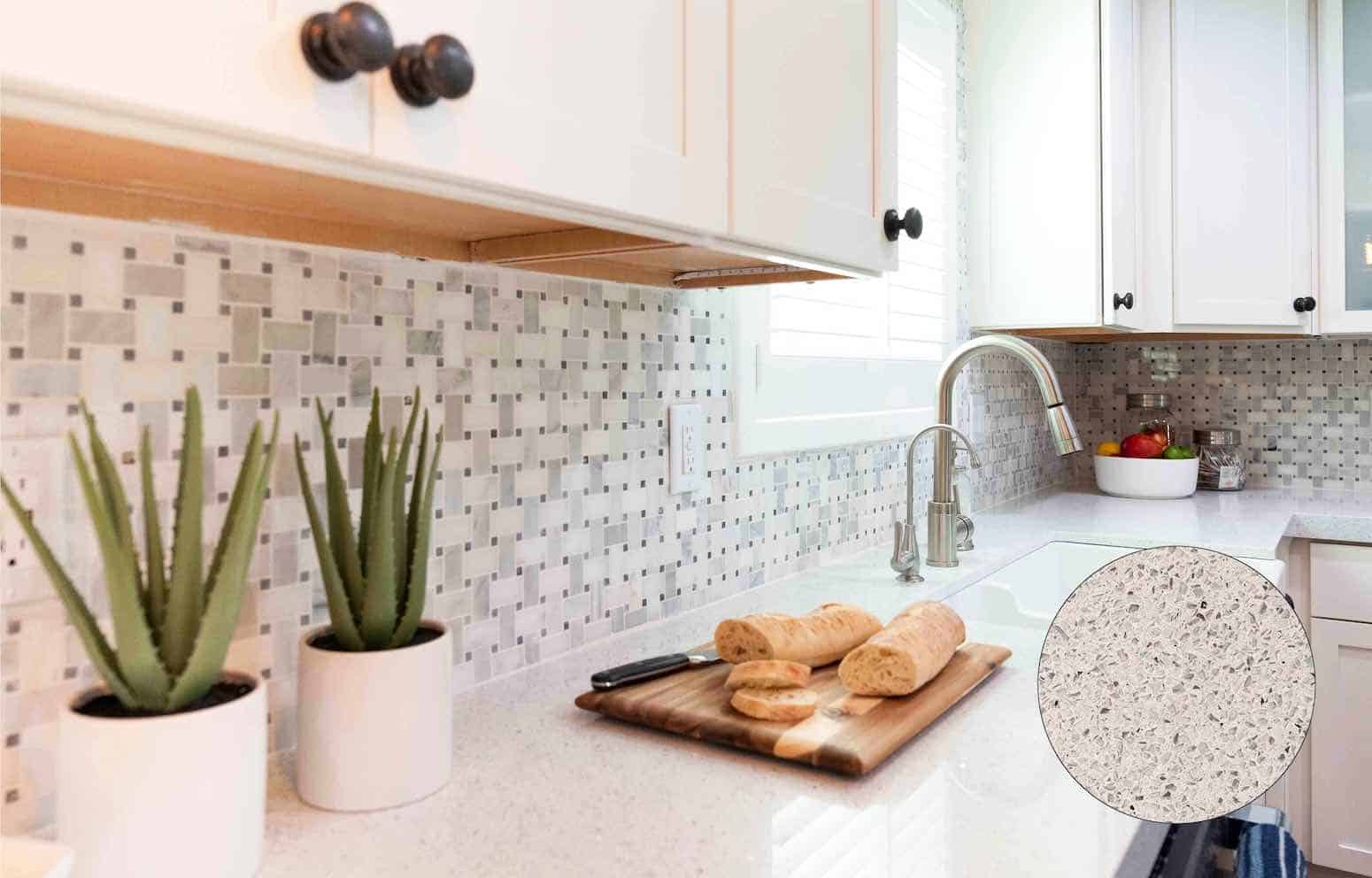 Modern kitchen countertop with white cabinets, mosaic tile backsplash, aloe plants in white pots