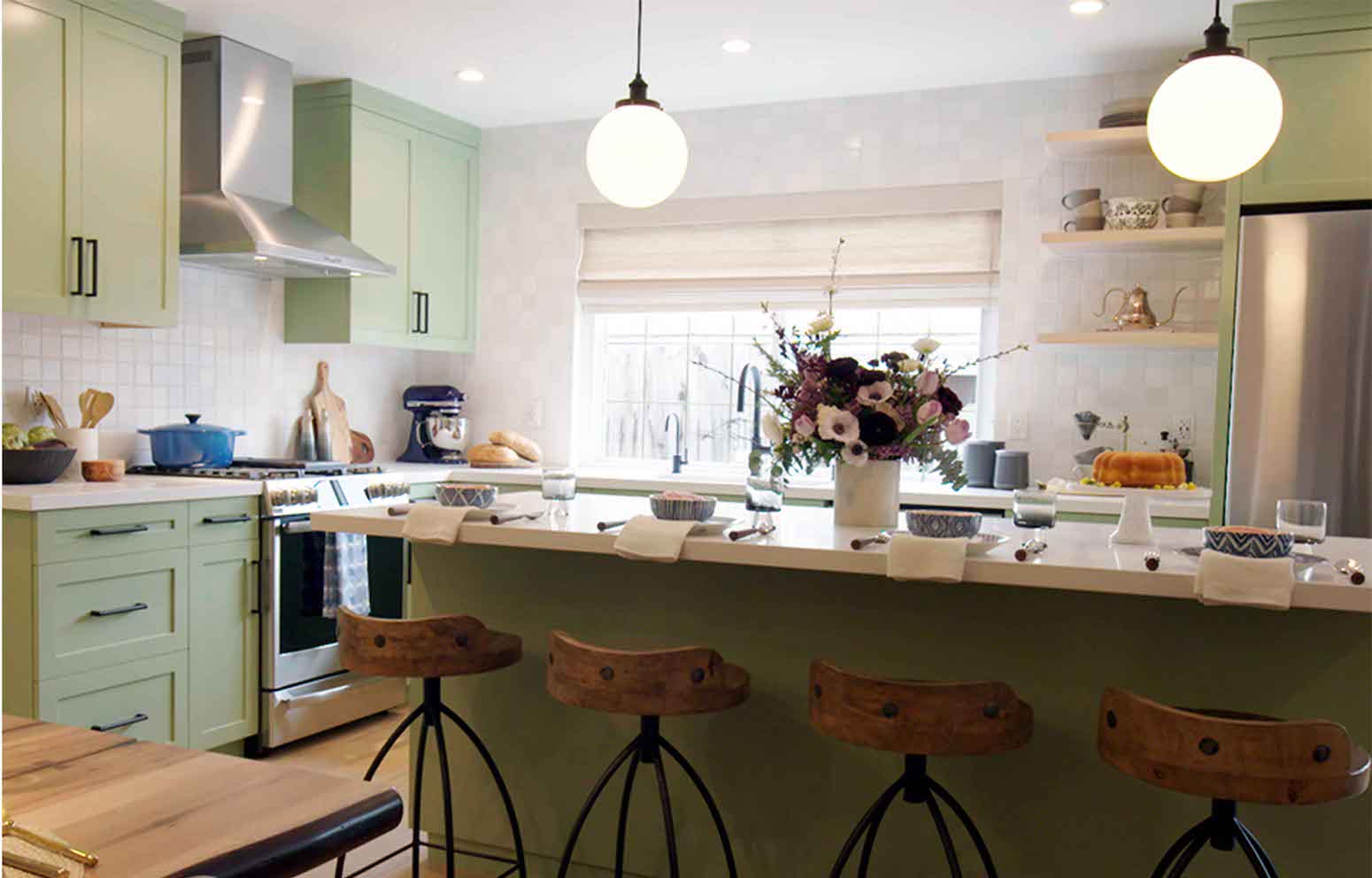 Kitchen with green cabinets, a breakfast bar, and floral centerpiece