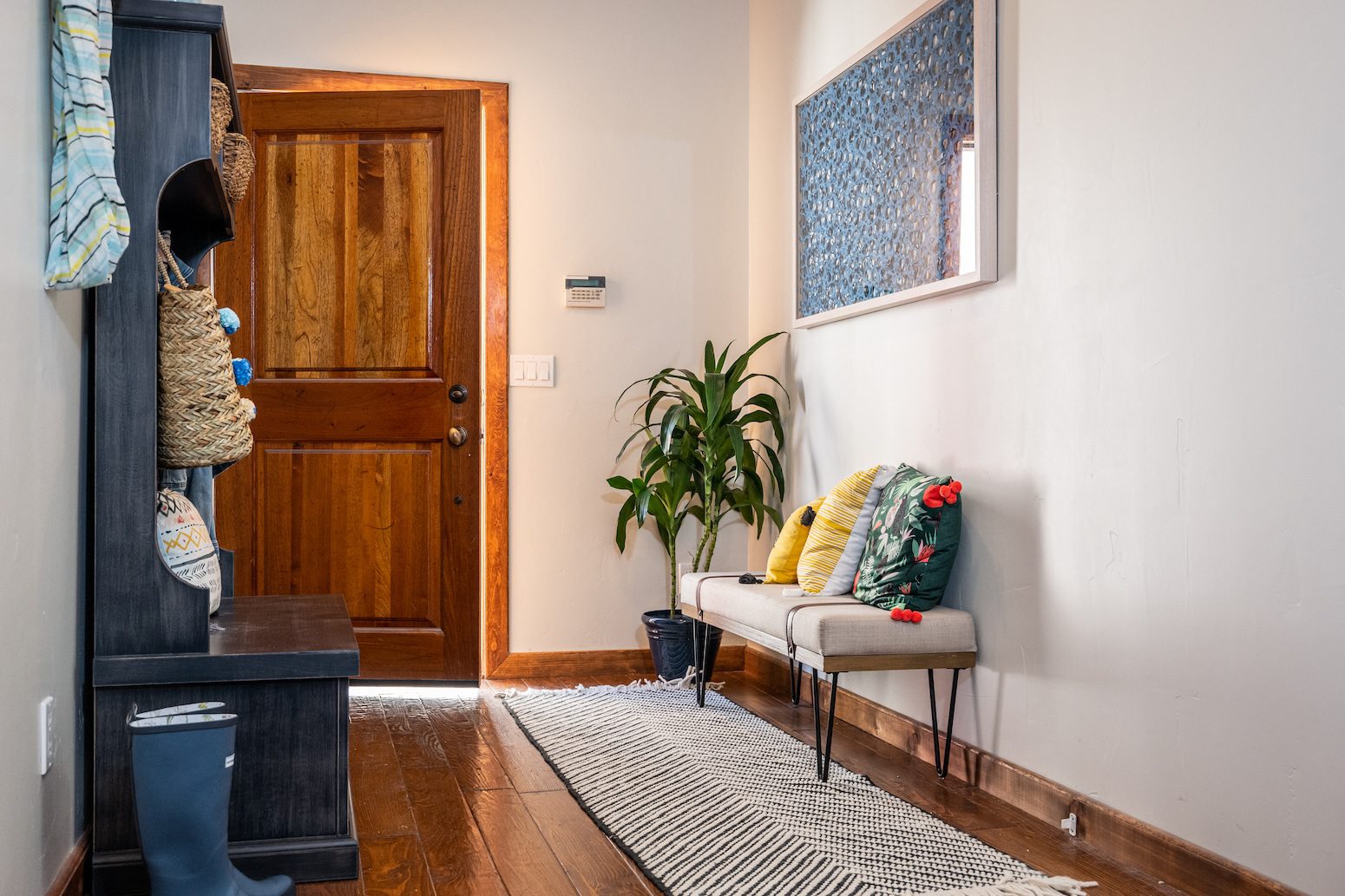Entryway with wooden door bench plants and colorful pillows