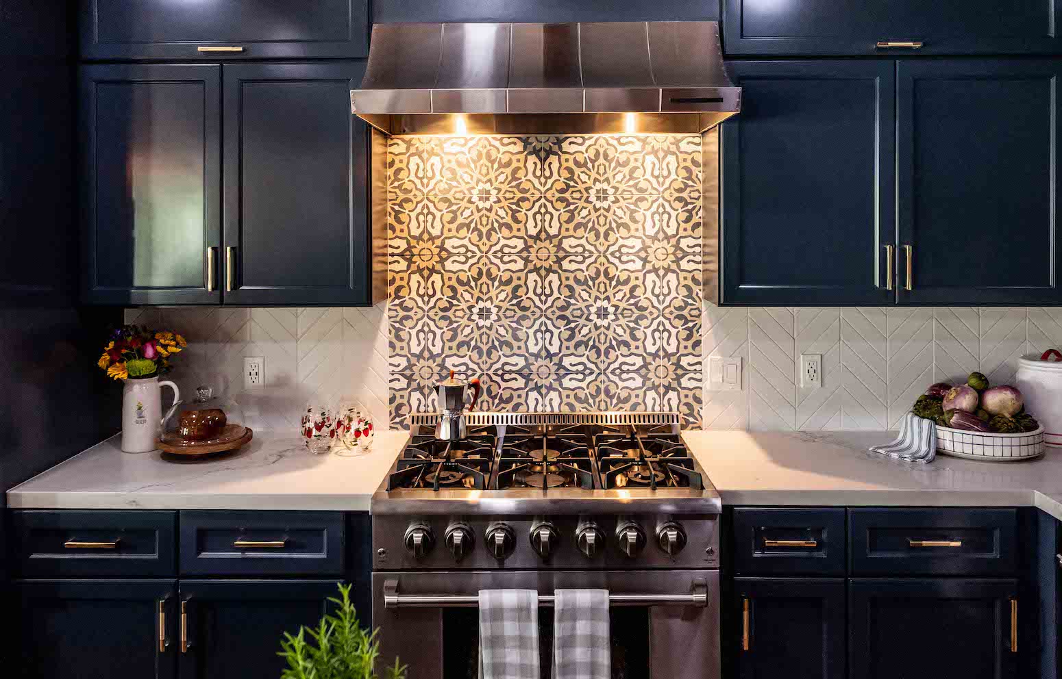 Kitchen with navy cabinets, patterned backsplash, and stainless steel stove